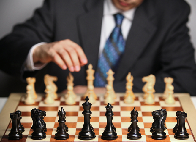Un homme en costume joue aux échecs