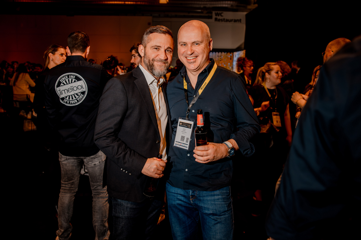 Zwei Partygäste posieren miteinander mit Bier in der Hand für ein Bild an der Break the Norm Networking Party am HR FESTIVAL europe.