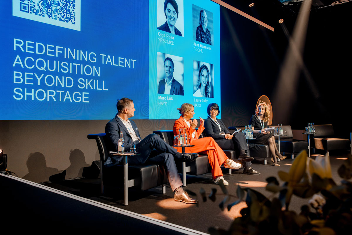 Vier Teilnehmerinnen und Teilnehmer der Panel Discussion Redefining Talent Acquisition beyond Skill shortage sitzen auf der Bühne.