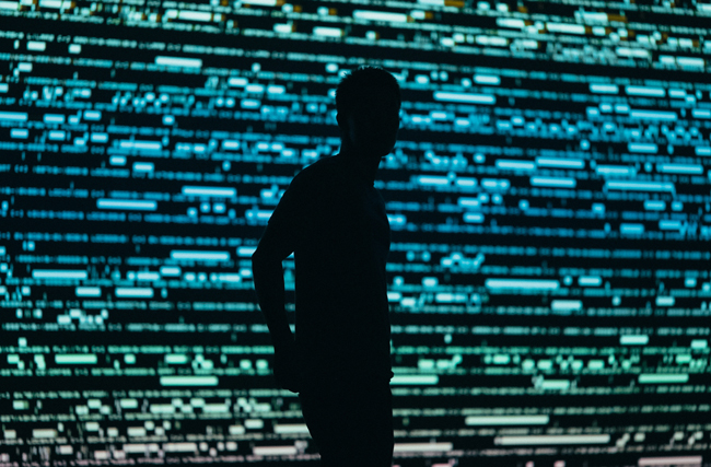 Silhouette eines Menschen vor einem überdimensionalen Bildschirm symbolisch für die digitale Überwachung und Einsatz von Mitarbeiterüberwachungssoftware
