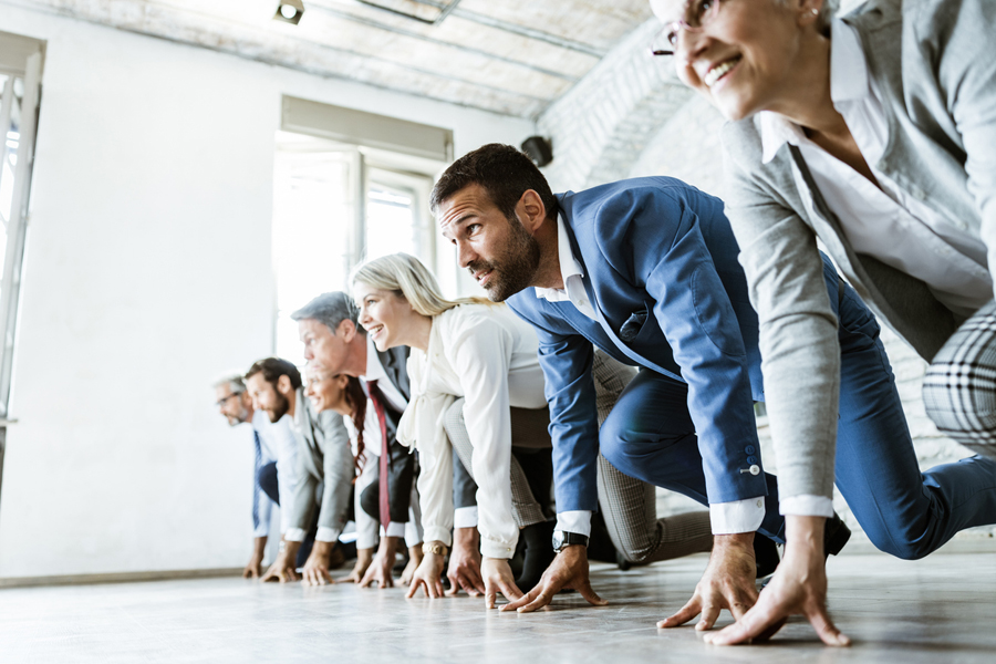 Un groupe d'hommes et de femmes sur une ligne de départ, prêts pour une course sportive au bureau