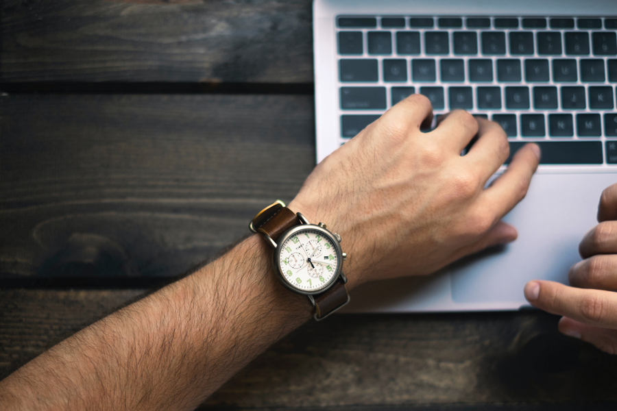 Vue de la montre d'un homme qui travaille sur son laptop