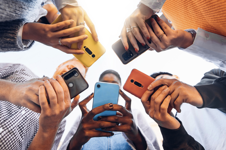 Des adolescents en cercle tiennent des smartphones