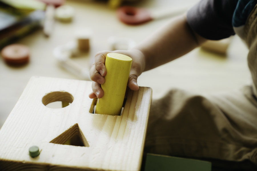 Un homme place une pièce dans un puzzle en bois