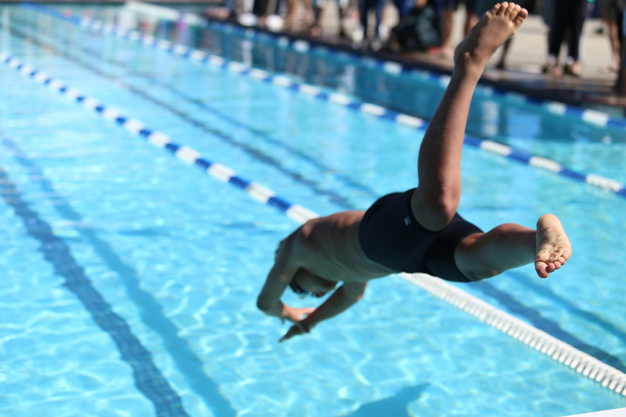 Un homme plonge dans une piscine