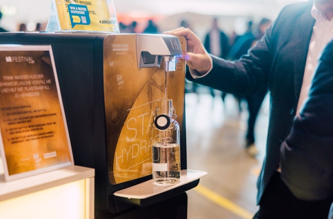 Jemand füllt eine Fill me Flasche an einer Kärcher Wasserstation auf am HR FESTIVAL europe