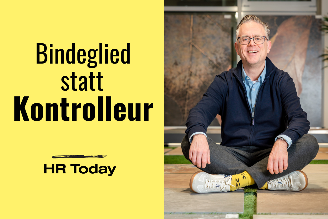 Zweiteilige Grafik mit gelbem Hintergrund links und einem Foto rechts. Links steht gross der Text: „Bindeglied statt Kontrolleur“, darunter das Logo „HR Today“. Rechts sitzt ein Mann im Schneidersitz auf Bodenmustern aus Fliesen und Kunstrasen, trägt Brille, eine dunkelblaue Strickjacke, hellblaues Hemd und auffällige gelbe Socken mit Motiv. Er lächelt in die Kamera, im Hintergrund sind grosse Wandplatten zu sehen.