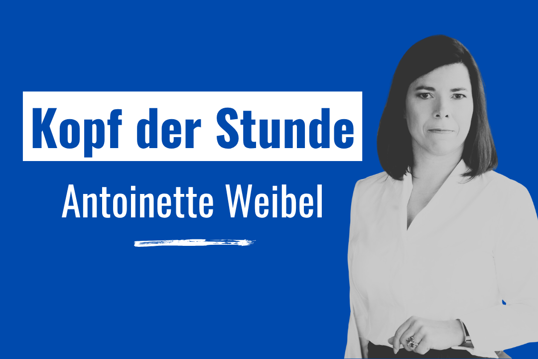 Eine Grafik mit blauem Hintergrund. Auf der linken Seite steht der Text "Kopf der Stunde" in dunkelblauer Schrift auf einem weißen Rechteck. Darunter steht in weißer Schrift der Name "Antoinette Weibel", unterstrichen mit einem stilisierten weißen Pinselstrich. Auf der rechten Seite befindet sich ein Schwarz-Weiß-Porträt von Antoinette Weibel, die direkt in die Kamera blickt.