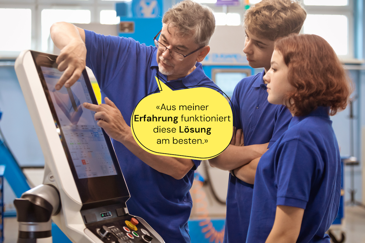 Mitarbeiter erklärt zwei Lernenden etwas