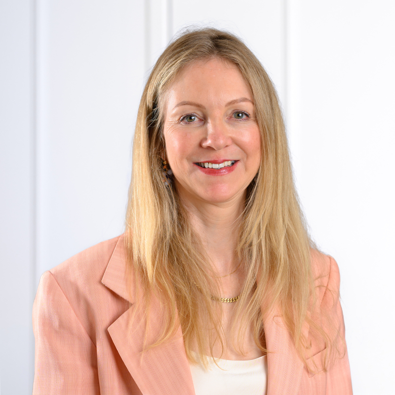 Barbara Kpnzle im lachsfarbenen Blazer, lange blonde Haare.