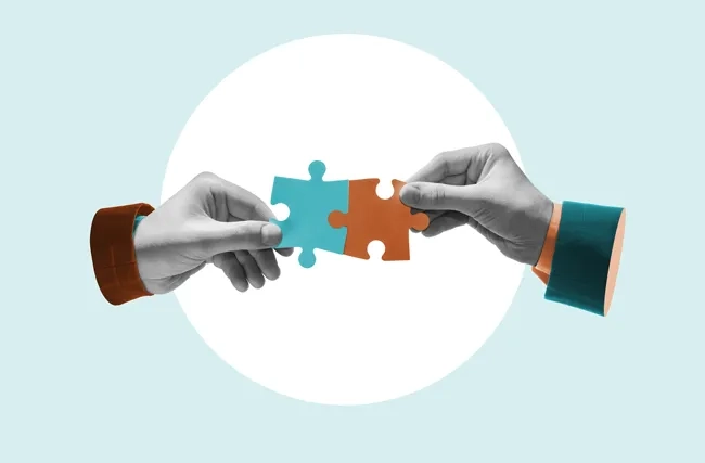 Zwei Hände setzen ein Puzzle zusammen