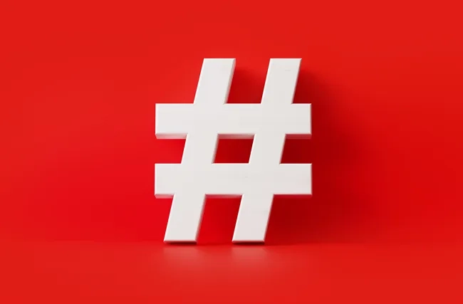 Symbolbild eines weissen 3D-Hashtags auf rotem Hintergrund