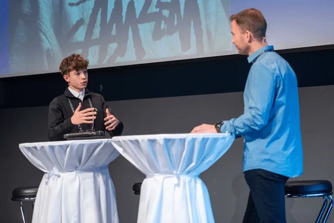 Lernender Noah Kristoffy in angeregter Diskussion mit Marc Marthaler, Head of Next Generation bei Swisscom, über das neue Rekrutierungssystem von Swisscom, das an der Next Talent 2024 vorgestellt wurde.