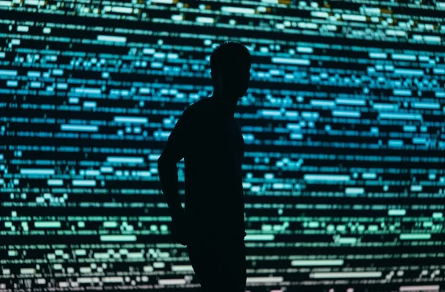 Silhouette eines Menschen vor einem überdimensionalen Bildschirm symbolisch für die digitale Überwachung und Einsatz von Mitarbeiterüberwachungssoftware