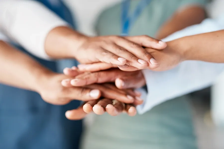 Travail temporaire et sécurité: une pile de mains de collègues solidaires