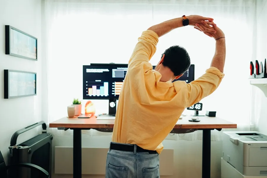 Un homme effectue des étirements dans son bureau