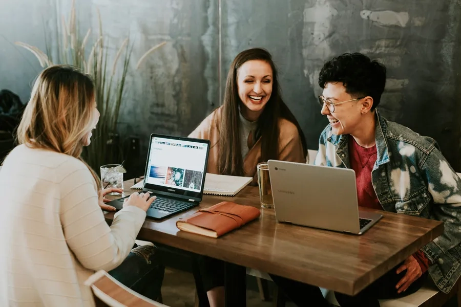 Humour au travail: trois collègues rient ensemble