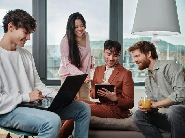 Eine diverse Gruppe an Leuten mit Laptops. 