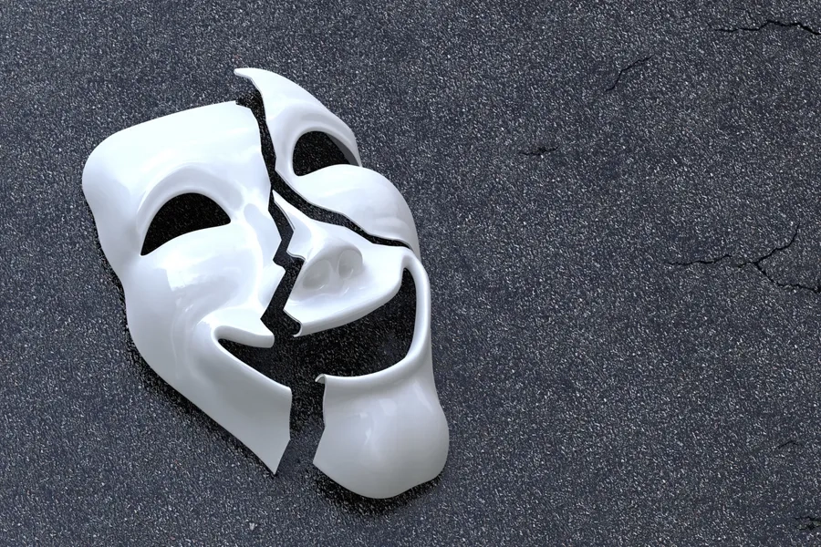 Un masque cassé sur une surface asphaltée