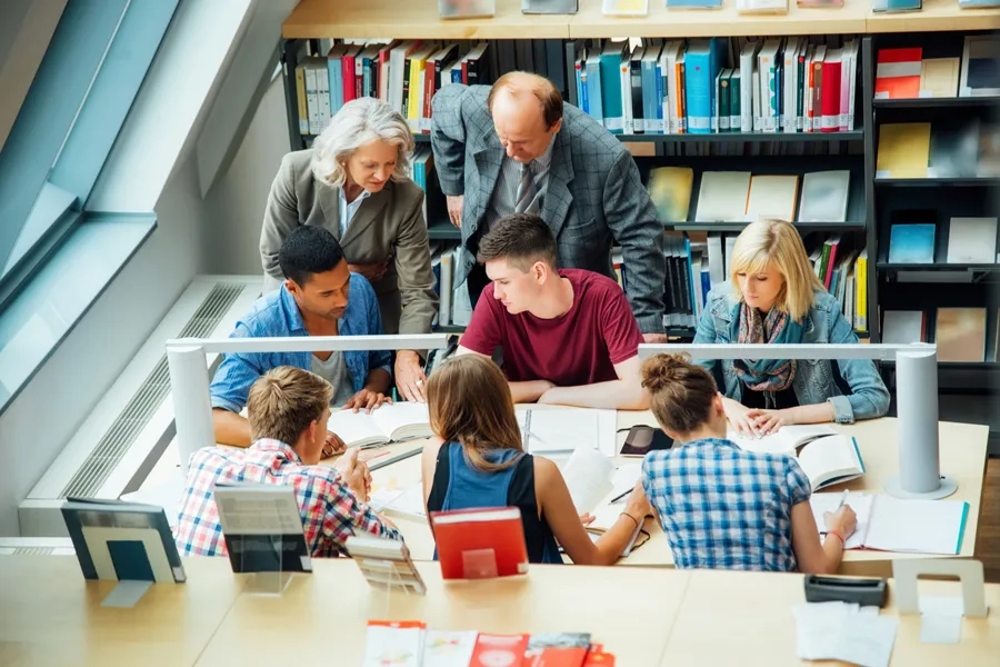 Professeurs observant des étudiants qui étudient à l'université