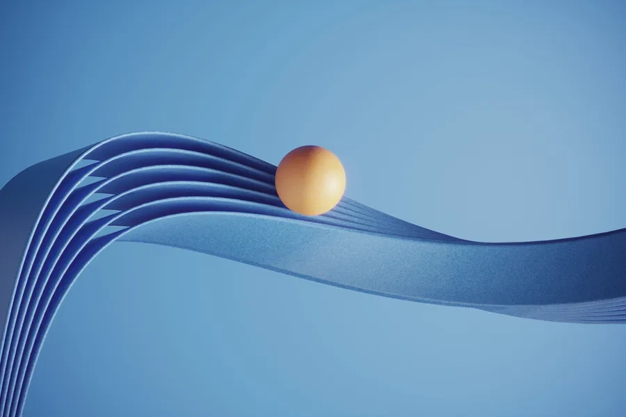 Boule orange posée sur des rubans bleus ondulés sur un fond bleu