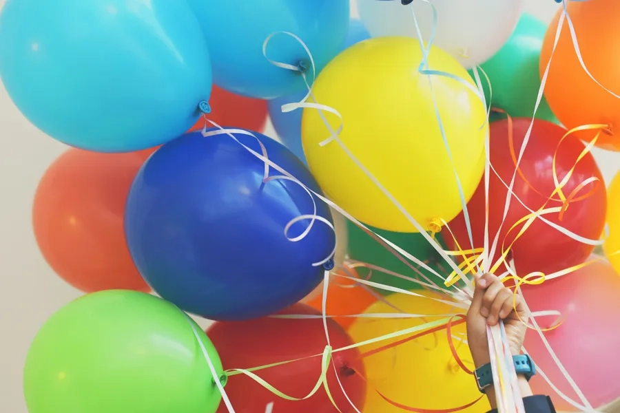 Une personne tenant des ballons colorés