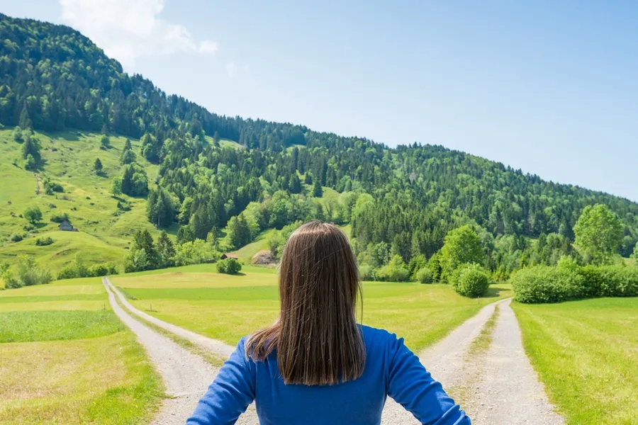 Une femme de dos à la croisée de deux chemins
