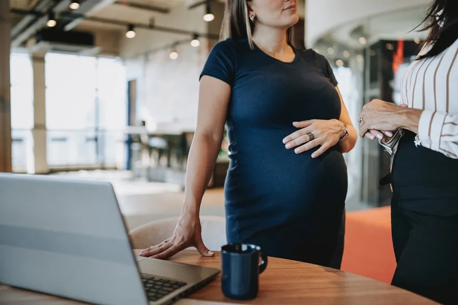 Une femme enceinte échange avec une collègue