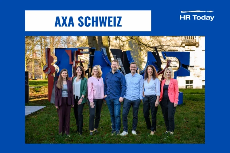 Grafik mit breitem blauem Rahmen. Oben steht in einem weißen Kasten in blauer Schrift „AXA SCHWEIZ“. Oben rechts befindet sich das weiße Logo von HR Today. Im Zentrum des Bildes ist ein Farbfoto derselben siebenköpfigen Gruppe aus dem ersten Bild zu sehen. Sie stehen draußen an einem sonnigen Tag auf einer Grünfläche vor einer großen, abstrakten, mehrheitlich blauen und roten Metallskulptur.